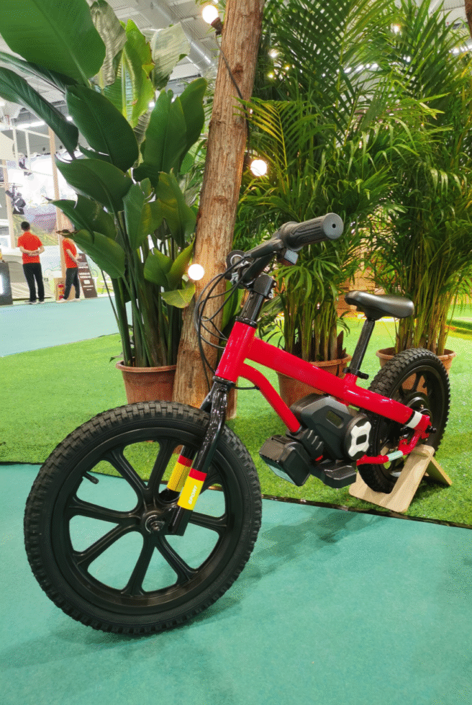 Kids electric balance bike displayed with colorful playground background
